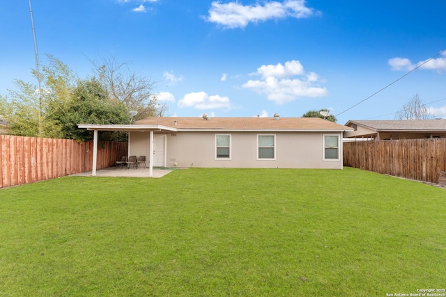 rear view of property with a yard and a patio