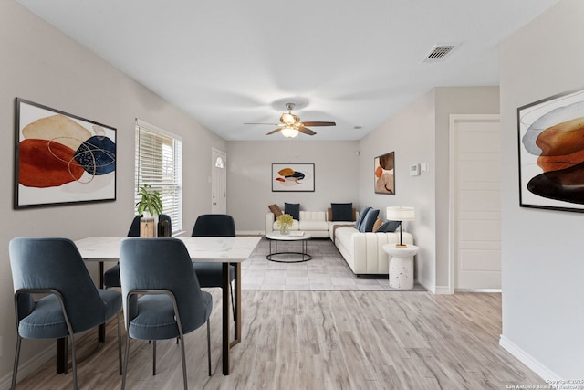 living room with light hardwood / wood-style flooring and ceiling fan