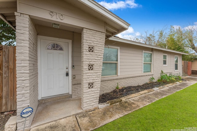 view of exterior entry with a yard