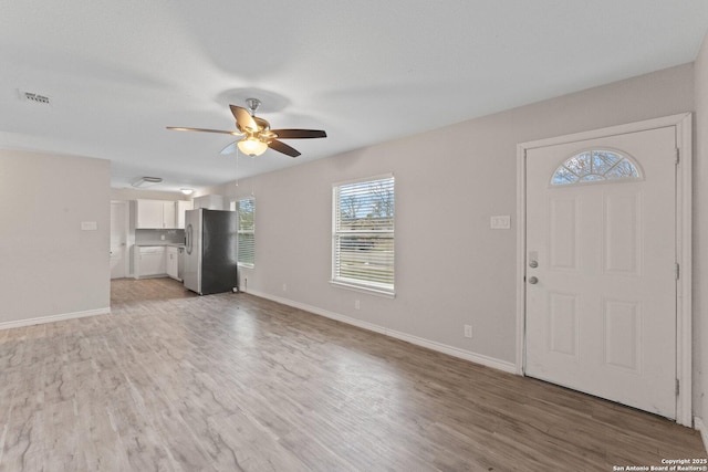 unfurnished living room with light wood-type flooring and ceiling fan