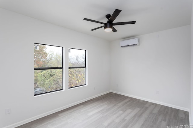 unfurnished room featuring a wall unit AC, ceiling fan, and light hardwood / wood-style floors