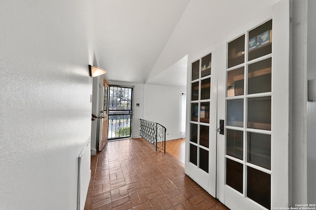 corridor with french doors and vaulted ceiling