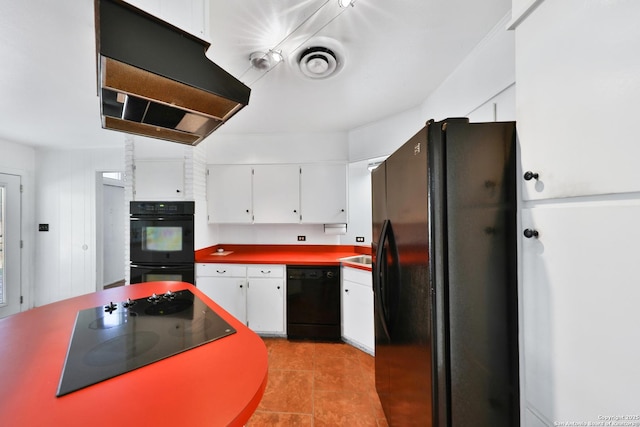 kitchen featuring exhaust hood, white cabinetry, light tile patterned floors, and black appliances