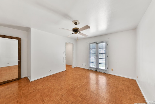 empty room with french doors, light parquet flooring, and ceiling fan