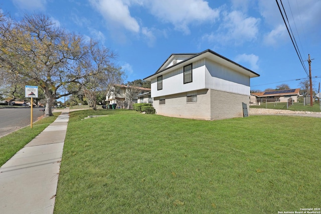 view of side of home with a yard