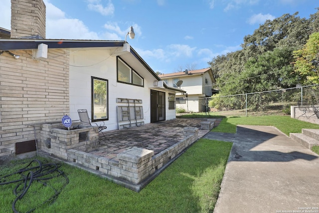 rear view of house with a lawn and a patio