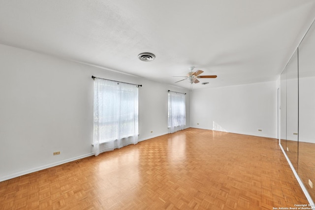 unfurnished room with ceiling fan and light parquet floors