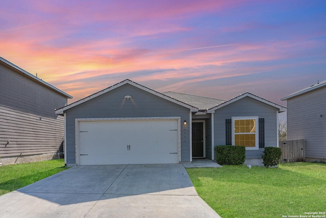 ranch-style house featuring a garage and a lawn