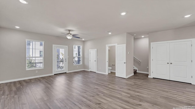 unfurnished living room featuring ceiling fan and light hardwood / wood-style flooring