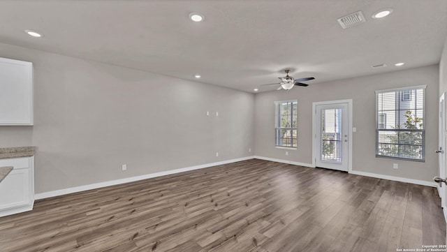 unfurnished living room with ceiling fan and wood-type flooring