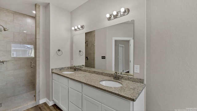 bathroom with an enclosed shower, wood-type flooring, and vanity