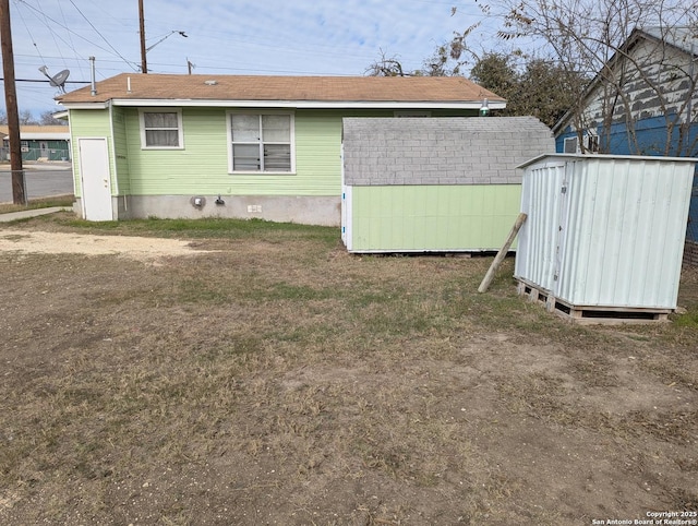 back of property featuring a storage unit