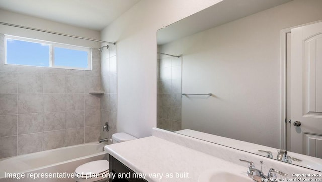 full bathroom with vanity, tiled shower / bath, and toilet