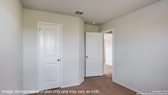 unfurnished bedroom featuring carpet and a closet