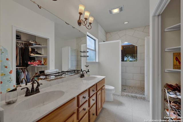 bathroom with vanity, toilet, and tiled shower