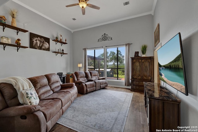 living room with hardwood / wood-style flooring, ceiling fan, and ornamental molding