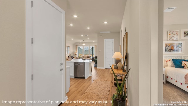 hall with light wood-type flooring and sink