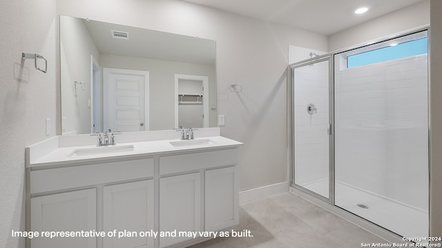 bathroom featuring a shower with door and vanity