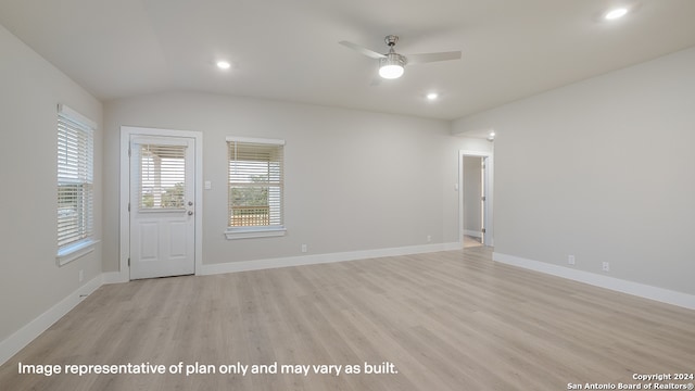 spare room featuring ceiling fan, light wood-type flooring, and lofted ceiling