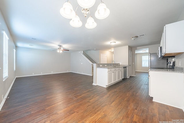 kitchen with white cabinetry, dishwasher, sink, hanging light fixtures, and ceiling fan with notable chandelier