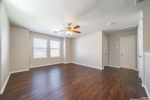 empty room with a textured ceiling, ceiling fan, and dark hardwood / wood-style floors