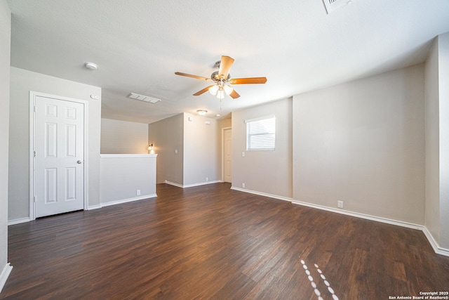 empty room with ceiling fan and dark hardwood / wood-style flooring