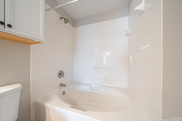 bathroom featuring tiled shower / bath combo and toilet