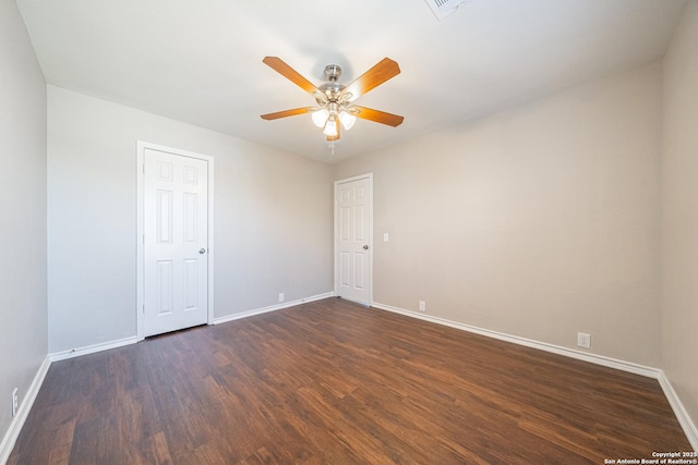 empty room featuring ceiling fan and dark wood-type flooring