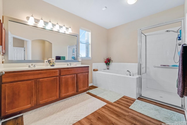 bathroom featuring vanity, wood-type flooring, and shower with separate bathtub