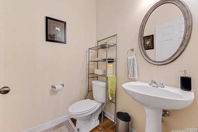 bathroom featuring hardwood / wood-style flooring and toilet