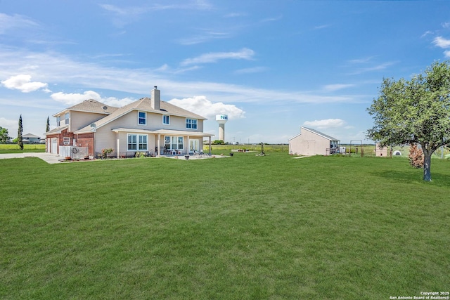 back of house with a yard and a patio