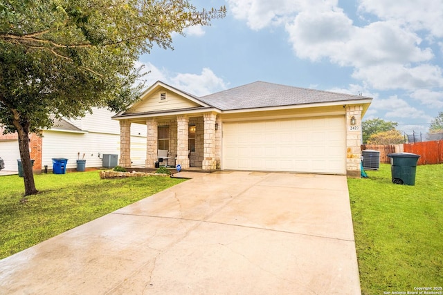 ranch-style home featuring cooling unit, a front yard, and a garage