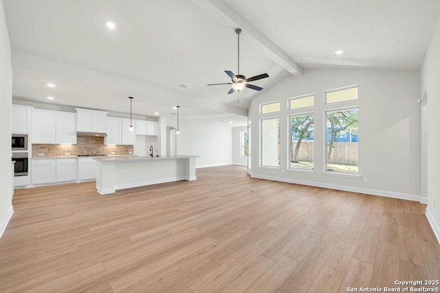 unfurnished living room with lofted ceiling with beams, light wood finished floors, baseboards, and a ceiling fan