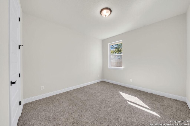 empty room featuring carpet floors and baseboards