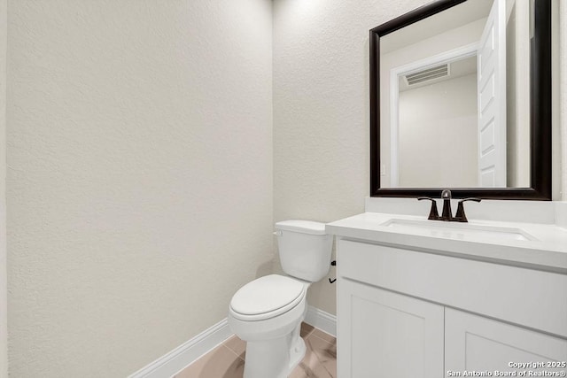 half bathroom with baseboards, visible vents, a textured wall, toilet, and vanity