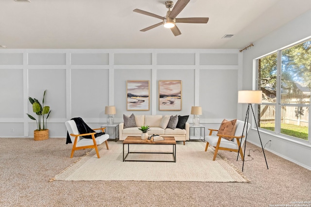 carpeted living room featuring plenty of natural light and ceiling fan