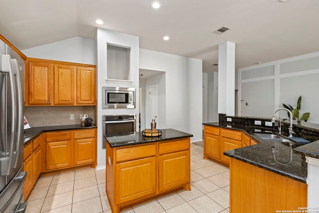 kitchen featuring dark stone countertops, sink, a center island, and stainless steel appliances