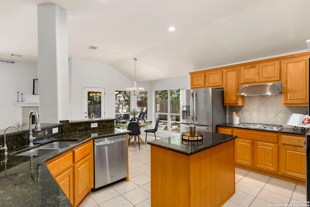 kitchen featuring dark stone counters, sink, decorative backsplash, stainless steel appliances, and a chandelier