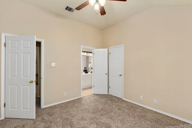 unfurnished bedroom with light carpet, ensuite bathroom, vaulted ceiling, and ceiling fan