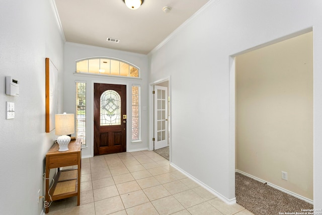 tiled entrance foyer featuring crown molding