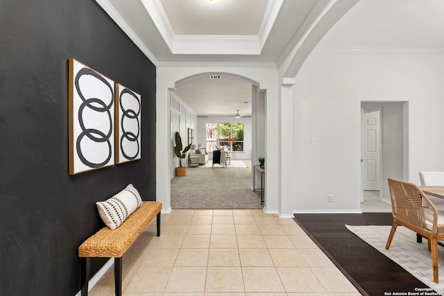 tiled foyer featuring crown molding and ceiling fan