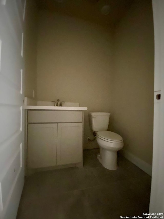 bathroom with tile patterned flooring, vanity, and toilet