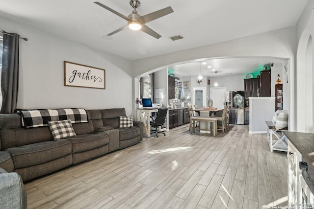 living room featuring ceiling fan and light hardwood / wood-style flooring