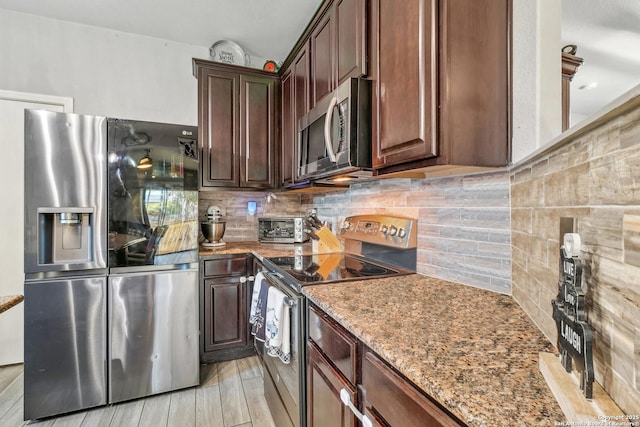 kitchen featuring appliances with stainless steel finishes, light hardwood / wood-style floors, light stone counters, and tasteful backsplash