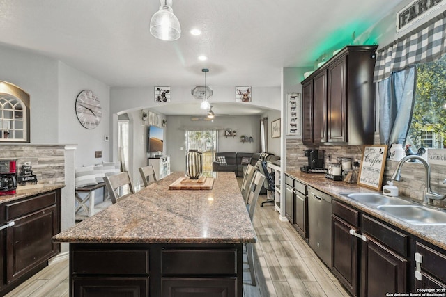 kitchen with decorative backsplash, a kitchen island, and sink