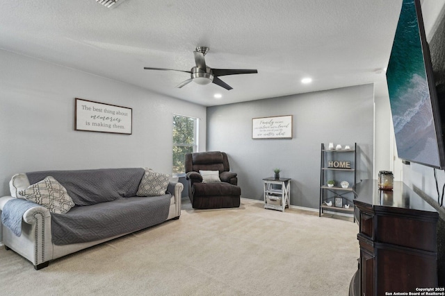 carpeted living room featuring a textured ceiling and ceiling fan