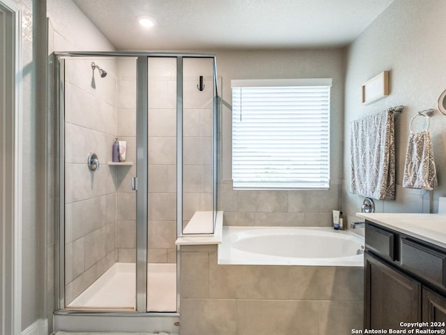 bathroom with vanity and independent shower and bath