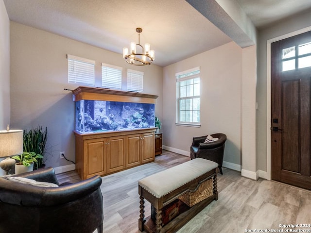 living room featuring a notable chandelier and light wood-type flooring