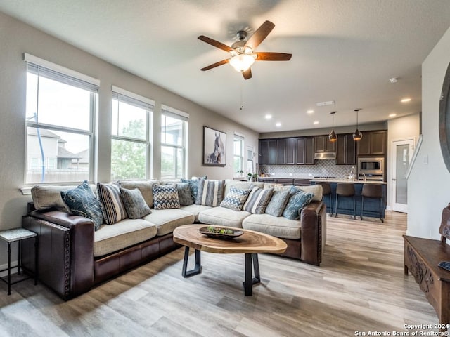 living room featuring ceiling fan and light wood-type flooring