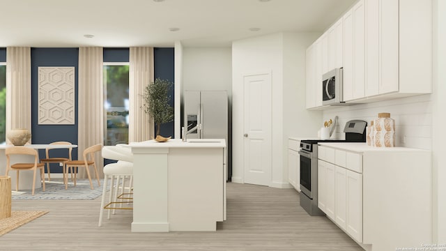 kitchen with a breakfast bar, stainless steel appliances, a center island with sink, white cabinets, and light hardwood / wood-style floors